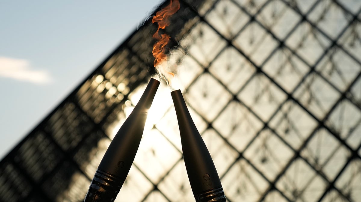 (AP Photo/Christophe Ena)
 : The Olympic torch is seen during a relay in the courtyard of the Louvre museum Sunday, July 14, 2024 in Paris. 